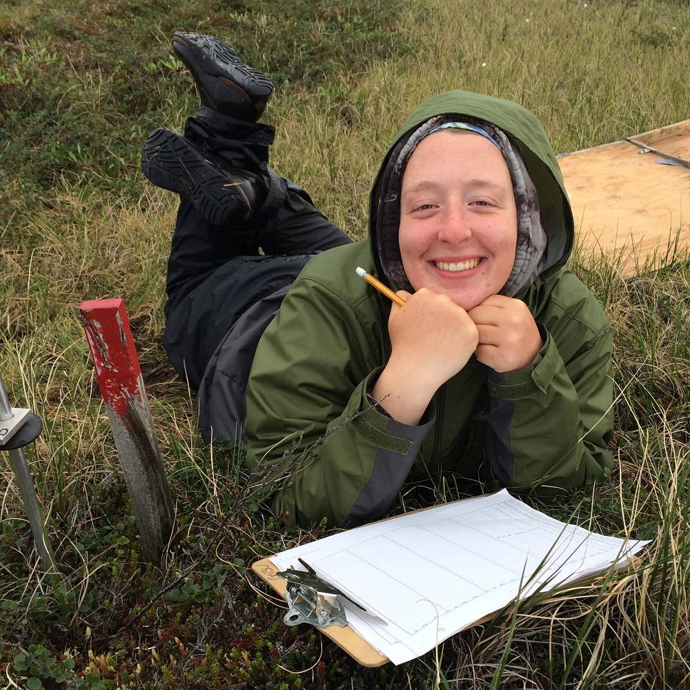 Hannah smiles from the tundra with a clipboard in front of her.
